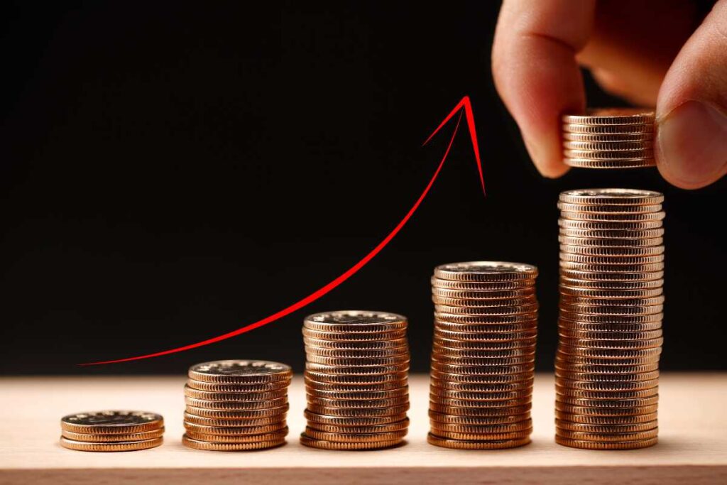 Illustrazione monete in pile sempre più alte e freccia che segnala un aumento