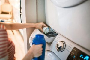 donna che mette detersivo in lavatrice