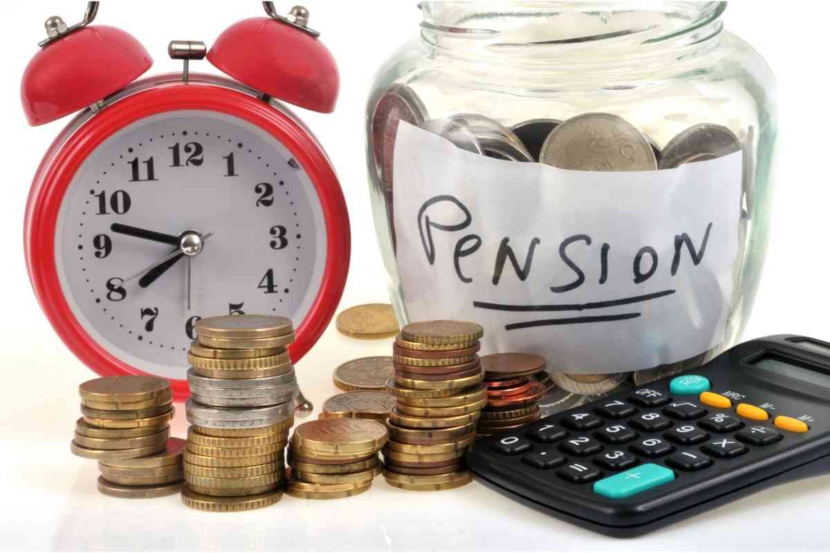 Scritta pension su barattolo con monete, sveglia e calcolatrice