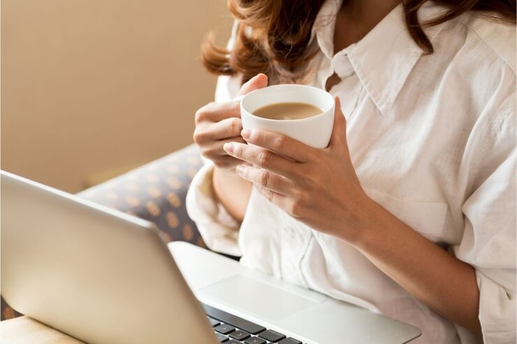 donna che tiene in mano una tazza di caffè