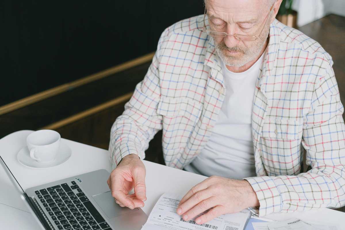 Un pensionato che controlla al computer un documento