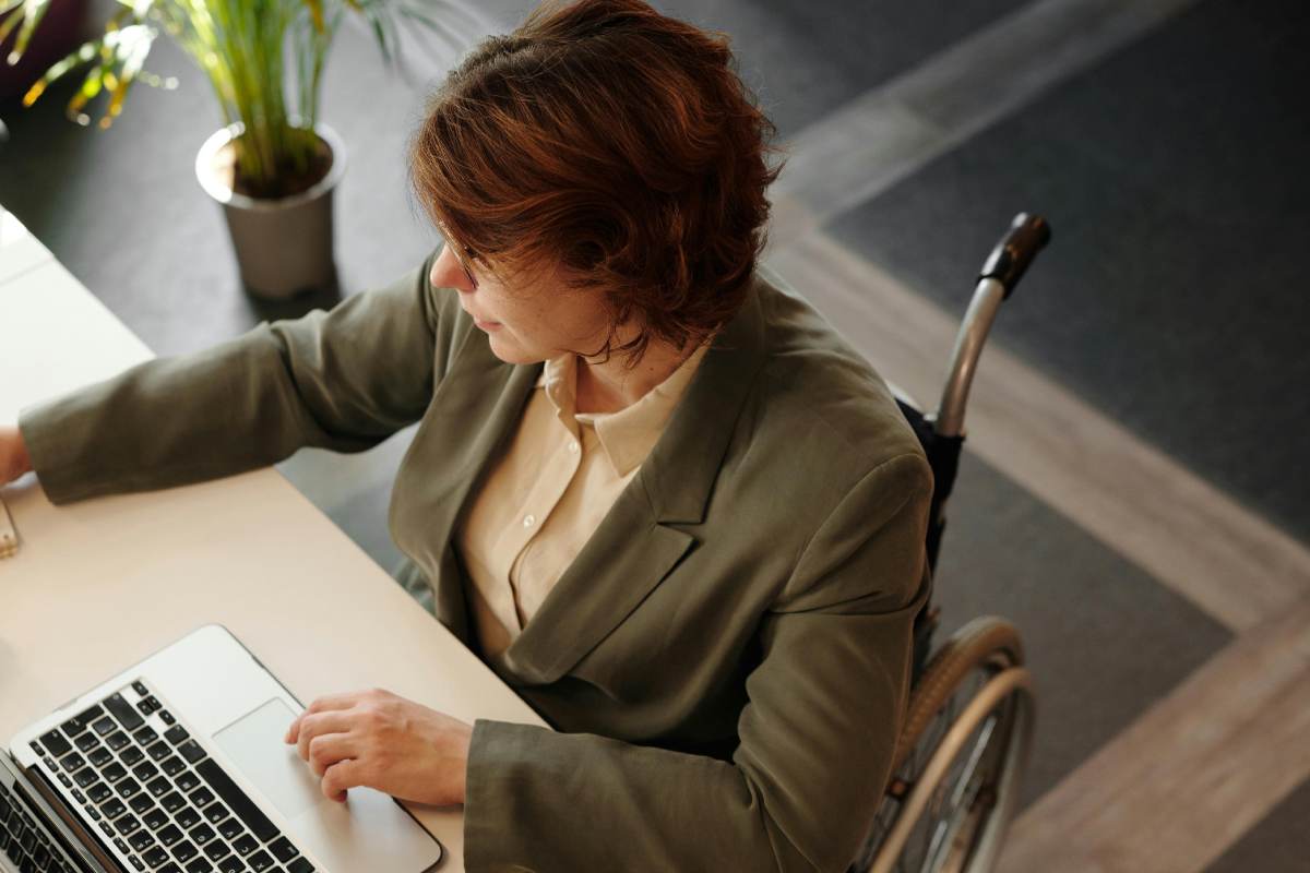 Una donna su sedia a rotelle che lavora al computer
