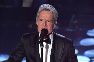 Primo piano di Claudio Baglioni che canta sul palco