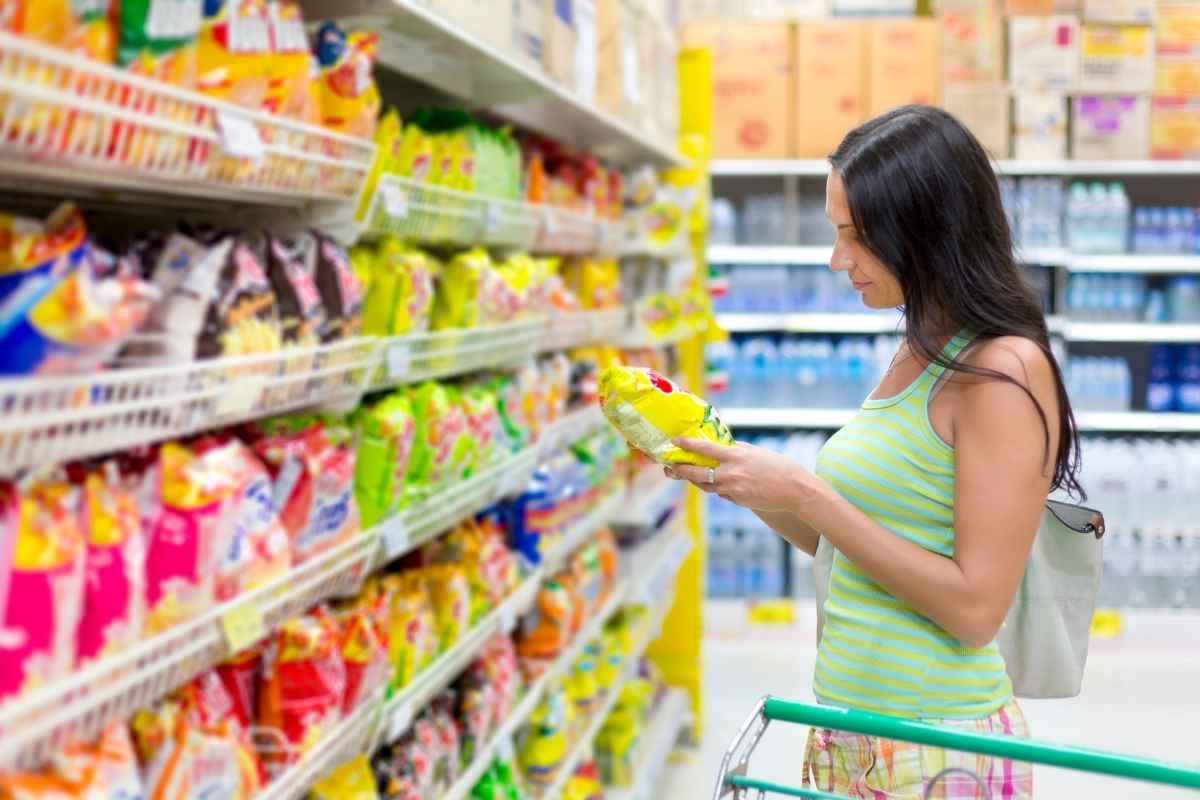 Donna sceglie patatine supermercato