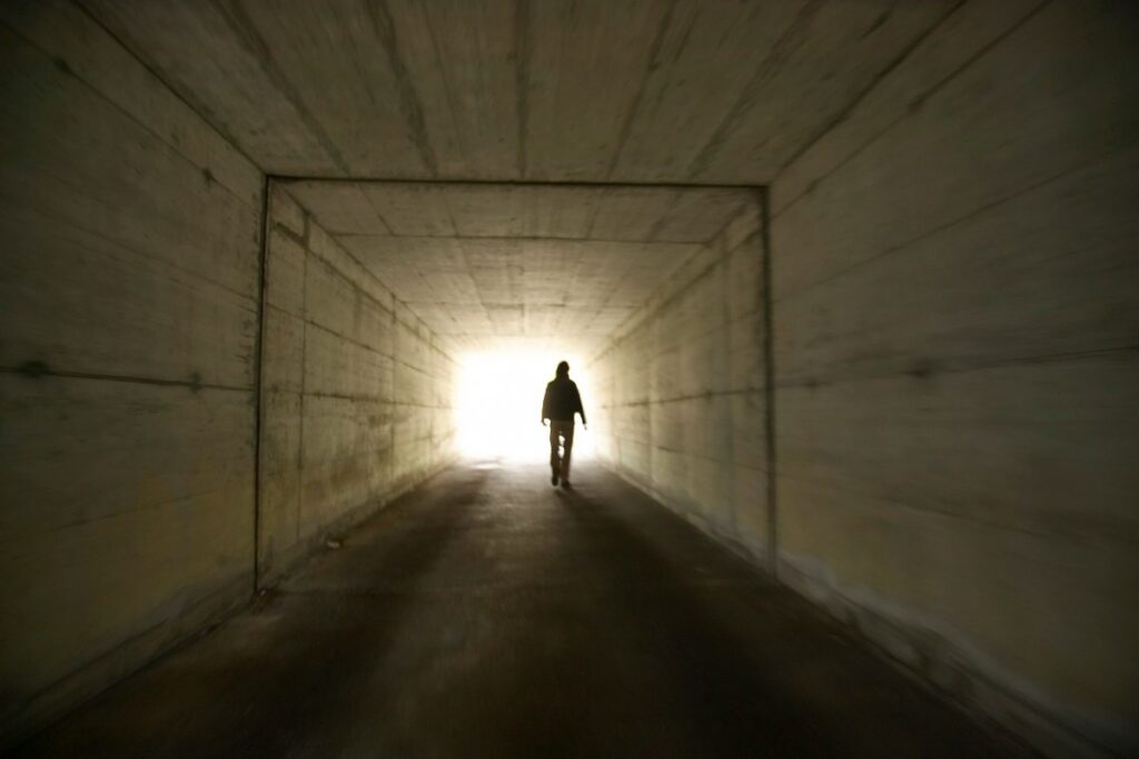 Uomo che trova la luce alla fine di un tunnel