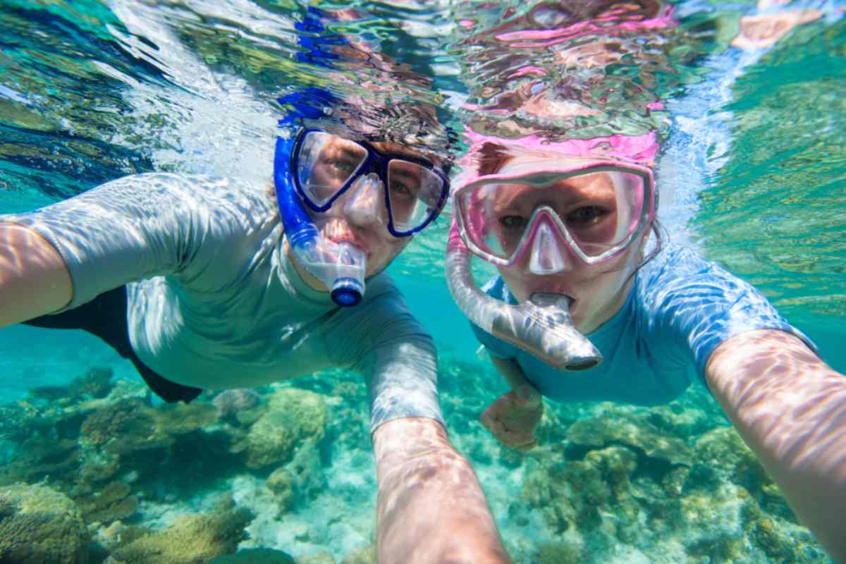Coppia sott'acqua che si fa un selfie con maschera e boccaglio