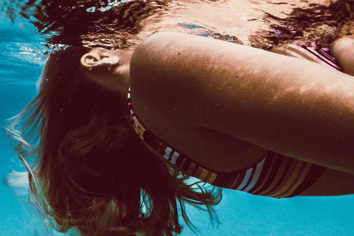 Ragazza a mollo in acqua al mare, particolare