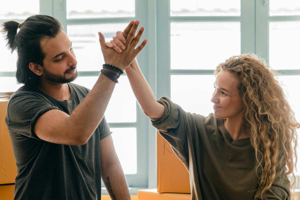 Due ragazzi che si danno il cinque in una casa nuova