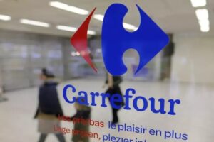 Una mamma e un figlio dietro la vetrina di Carrefour