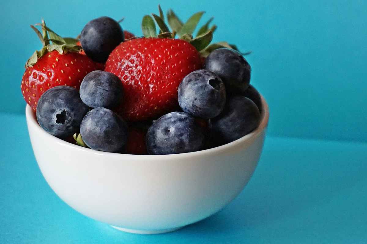 Una ciotola con frutta fresca: fragole e lamponi