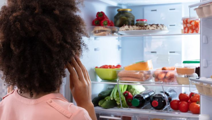 Donna di spalle davanti a un frigo aperto