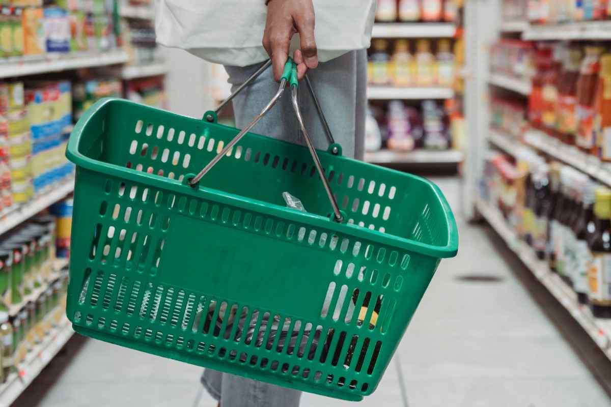 Un uomo con un cestino verde al supermercato