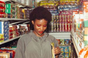 Ragazza che mangia uno snack in un supermercato