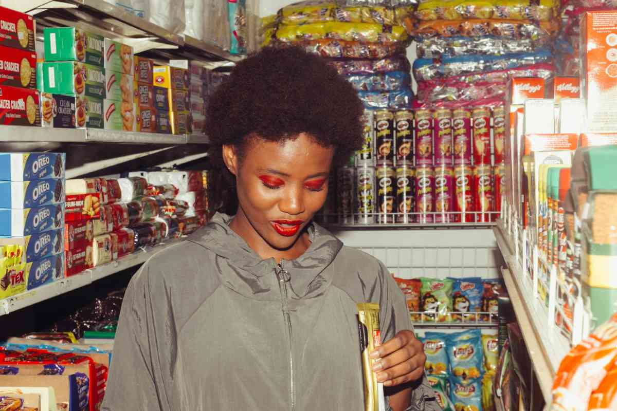 Ragazza che mangia uno snack in un supermercato