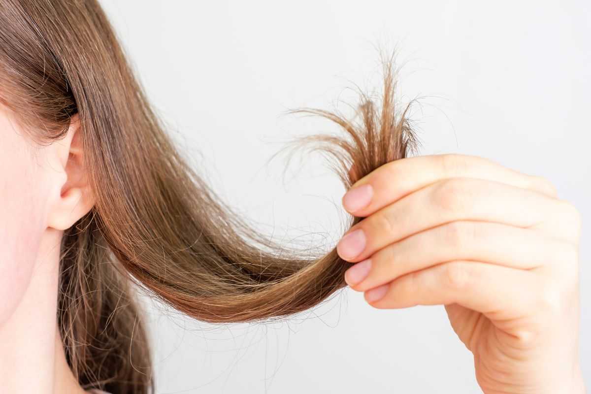 donna con ciocca di capelli in mano