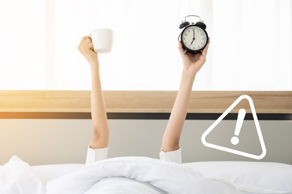 persona che mantiene sveglia e tazza di caffè nel letto
