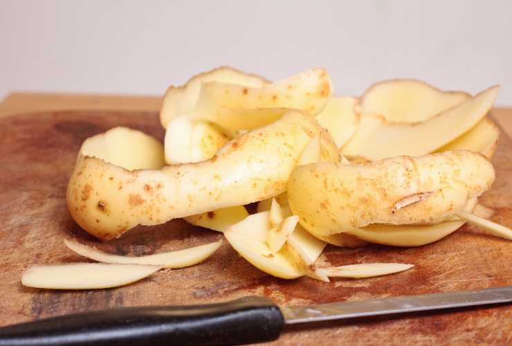 bucce patate e coltello sul tagliere