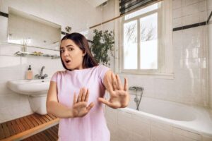 donna disgustata in un bagno di casa
