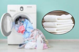 Asciugamani bianche e lavatrice nello sfondo