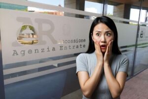 vetrata dell'agenzia delle entrate e donna spaventata